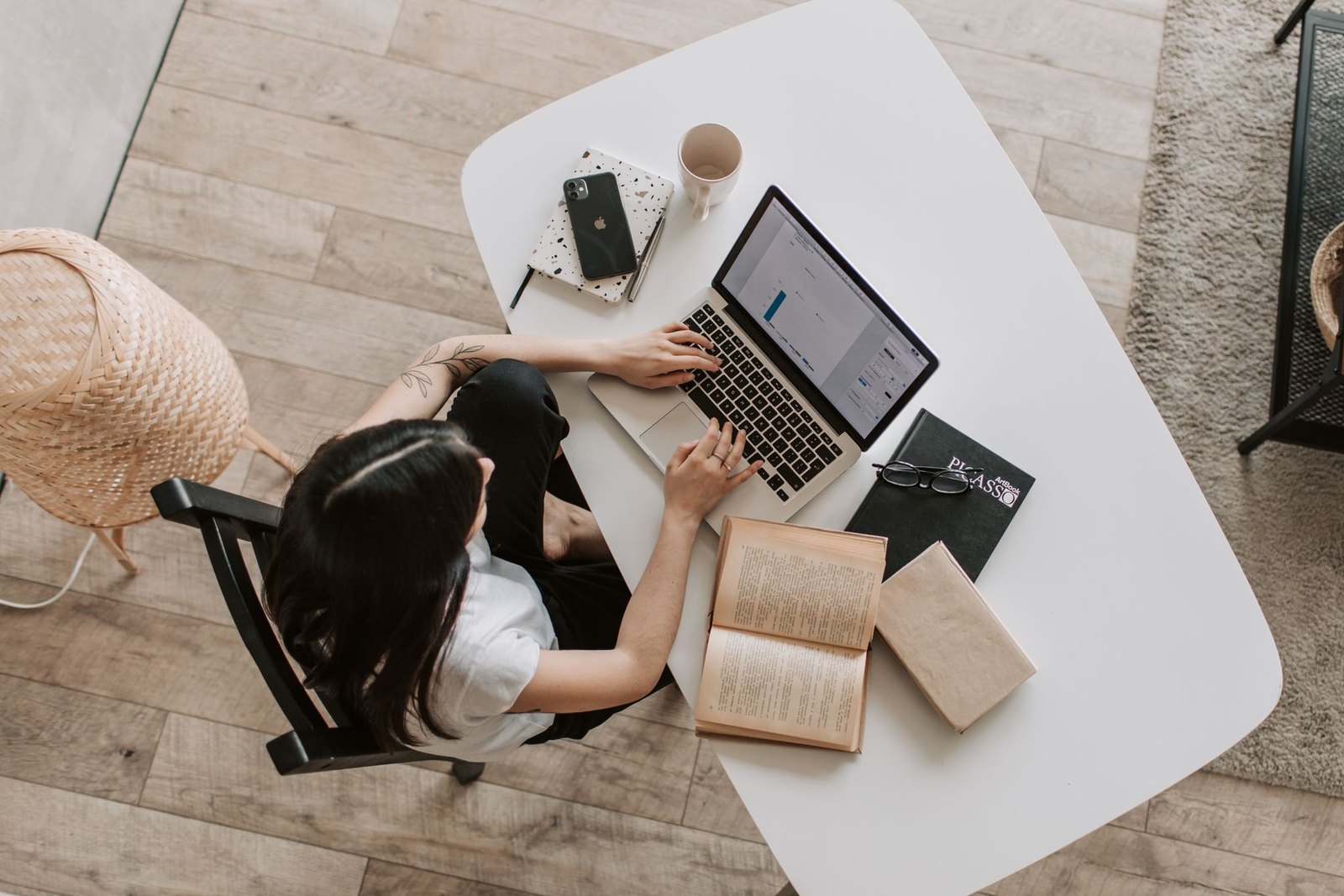 An overhead view of a founder working at a laptop with notes nearby